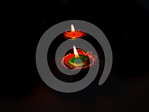 Lit diyas for celebrating Festival of lights placed with black background