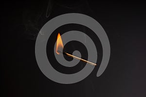 Lit falling match on a black background