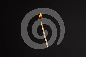 Lit falling match on a black background