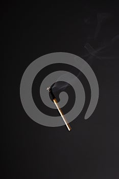 Lit falling match on a black background
