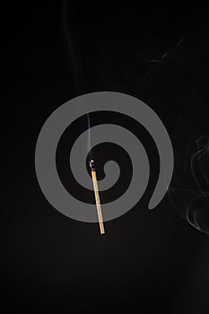 Lit falling match on a black background