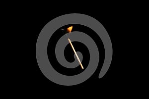 Lit falling match on a black background