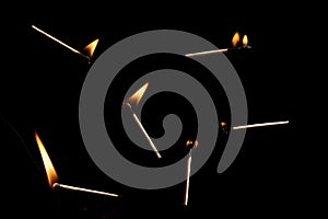 Lit and falling match on a black background