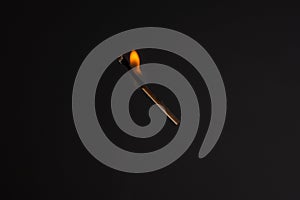 Lit falling match on a black background