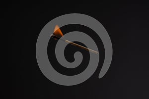 Lit falling match on a black background
