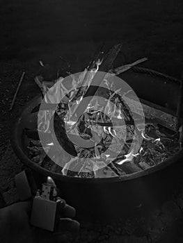 Lit Fire in Metal Pit In Wyoming WIth Zippo Lighter Flame Coming Out Sticks In Fire Grayscale