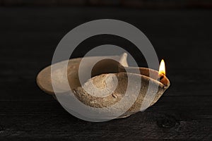 A Lit Handmade Oil Lamp from the Middle East on a Dark Table