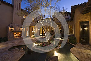 Lit House And Pond In Courtyard