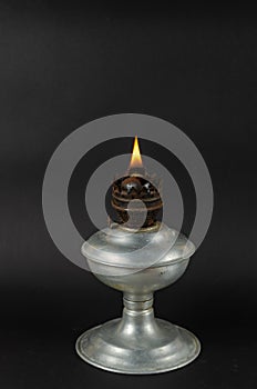 A lit kerosene lamp in front of the Gray background