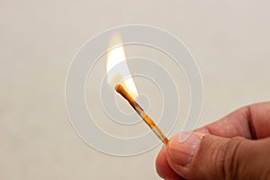 Lit match in hand. A lit match on a white background. Lighted match in hand on white background. Burning match in hand. Burning