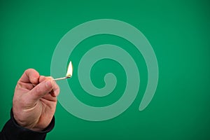 Lit matchstick held in hand by Caucasian male hand studio shot isolated advertising Green background chromakey free