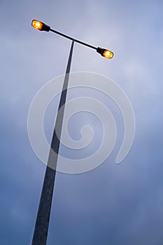 Lit modern streetlamp at evening or early night