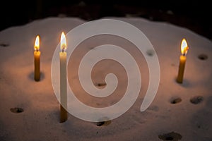 Lit prayer candles standing in sand at a church