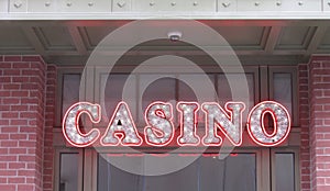 Illuminated casino sign hanging outside entrance to a casino