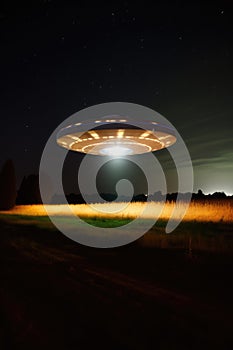 Lit ufo hovering above field at night, created using generative ai technology