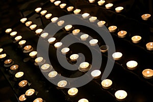 lit candles with the flame by pilgrims during the religious service inside the church of god