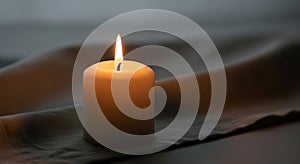 A lit white cylindrical candle on