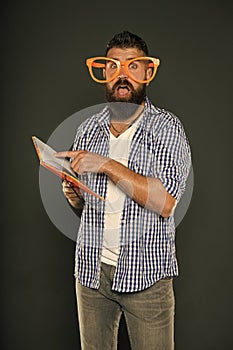 Literary club. Reading book as hobby. Study is fun. Hipster bearded man funny eyeglasses hold notepad or book. Read this