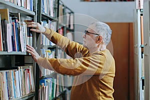 Literary Decision Portrait of a Senior Man Choosing a Book from the Shelf