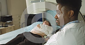 Lithotripsy for kidney and ureteral stones in modern center. Professional African man doctor, using ultrasound scan to