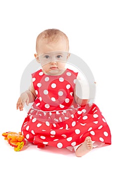 Litle baby girl with red dress, playing with toys, isolated