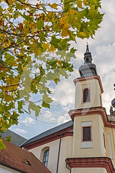 Litomysl, Czech Republic, Tower od Church of the Discovery of the Holy Cross with leaves in autumn, Church is in baroque