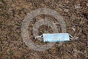 Litter along a roadside - disposable face mask