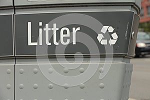 litter caption writing and recycle symbol on garbage with car passing on road-