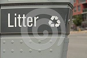 litter caption writing and recycle symbol on garbage with road and building-