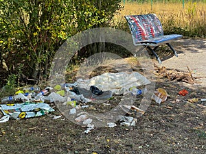 Littered park. Scattered trash. Littering garbage nature.