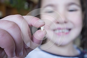 Little 5 years old girl showing her first baby tooth fallen out