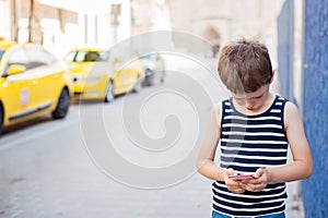 Little 7 years old boy playing mobile games on smartphone