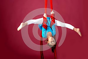 Little acrobat girl doing splits in the air