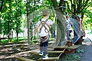 Little active boy who climbs on a rope the way to the amusement Park.