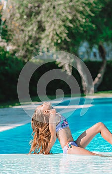 Little adorable girl in outdoor swimming pool