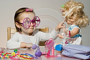 Little adorable girl playing with doll