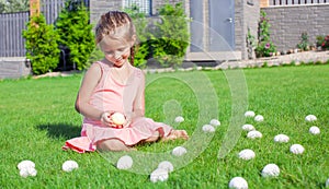 Little adorable girl playing with white Easter