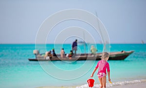 Little adorable girl walking with beach toys during tropical vacation