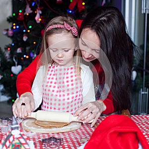 Little adorable girl and young mother baking