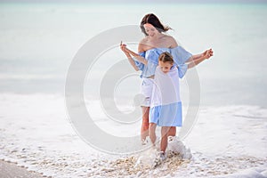 Little adorable girl and young mother at tropical beach