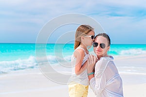 Little adorable girl and young mother at tropical beach