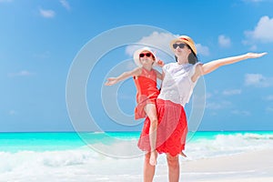 Little adorable girl and young mother at tropical beach. Family of two have a lot of fun during summer vacation