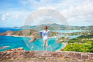 Little adorable kid with beautiful famous view. View of English Harbor from Shirley Heights, Antigua, paradise bay at