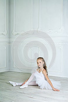 A little adorable young ballerina in a playful mood in the inter