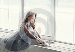 A little adorable young ballerina in a playful mood in the inter