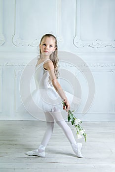 A little adorable young ballerina in a playful mood in the inter