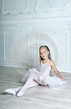 A little adorable young ballerina in a playful mood in the inter