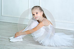 A little adorable young ballerina in a playful mood in the inter