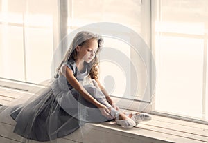 A little adorable young ballerina in a playful mood in the inter