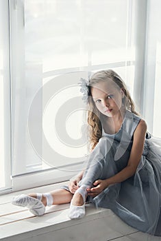 A little adorable young ballerina in a playful mood in the inter